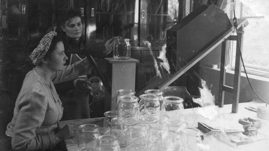 Huta szkła "Krosno". Kobiety podczas badania barwy szkła na wykonanych słoikach. Źródło: Narodowe Archiwum Cyfrowe. Rok: 1944